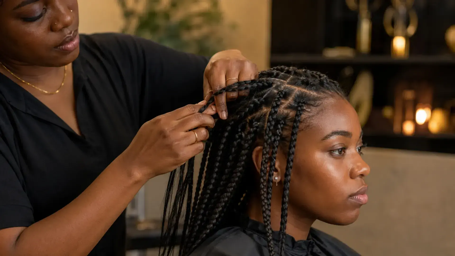Profissional africana a realizar manutenção das raízes das tranças